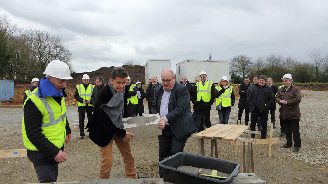 Ludovic Jolivet, président de Quimper Communauté et Michaël Quernez, vice-président du Conseil départemental délégué à l’économie posent la première pierre de la centrale biogaz au Petit Guélen, sous l’œil de Clothaire Lefort, directeur de Vol-V Biomasse.